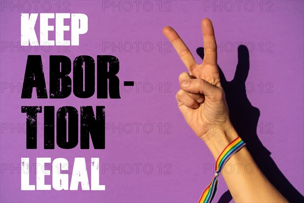 A woman with the symbol of victory or peace with a text in favor of the legalization of abortion