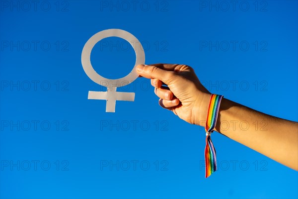 Blue sky background with a hand of a woman with female symbol in favor of feminism