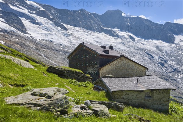 Alpine hut in front of glacier