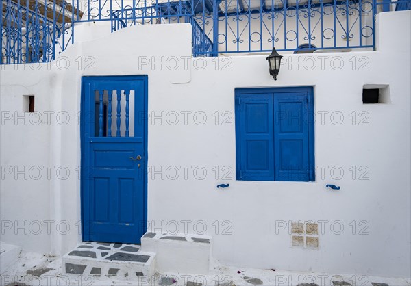 House facade with blue entrance door and shutters