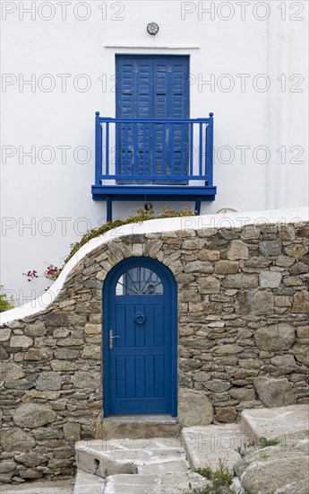 House facade with blue entrance door and shutters