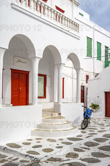 White Cycladic house with columns and red door