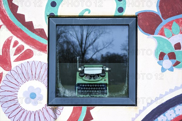 Window with old typewriter and wall painting in the former Olympic Village