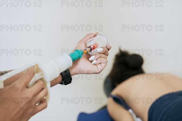 Close up of professional performing cupping treatment on patient