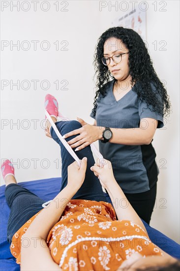 Kinesiologist with patient knee with resistance band