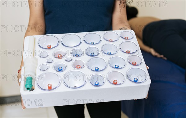 Physiotherapist hands holding cupping cups