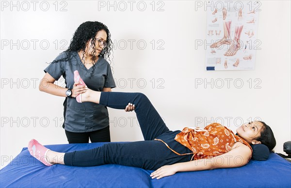 Physiotherapist assisting young patient in rehabilitation center