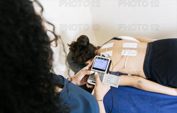 View of physiotherapist electrostimulating a patient