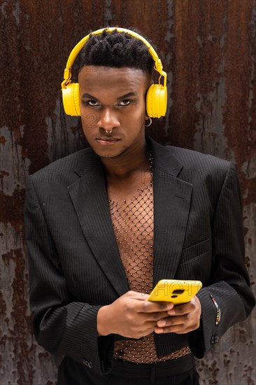 A man of black ethnicity listening to music wireless yellow headphones