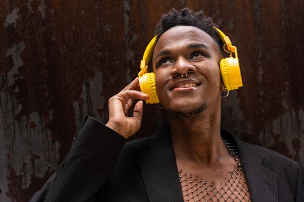 Portrait of a black ethnic man listening to music wireless yellow headphones