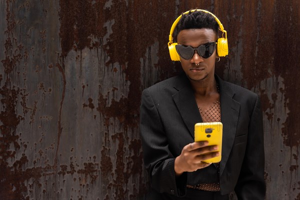 A black ethnic man listening to music wireless yellow headphones