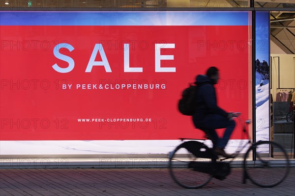 Illuminated shop window with poster Sale