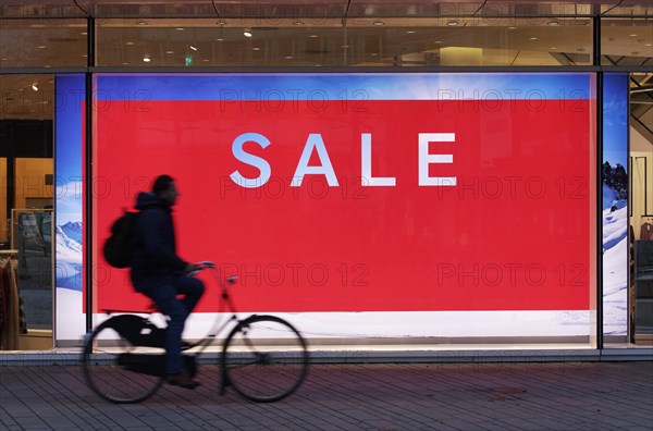 Illuminated shop window with poster Sale