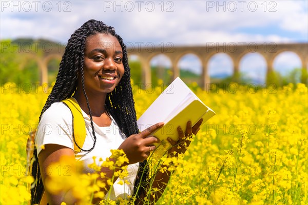 Reading a book in nature smiling