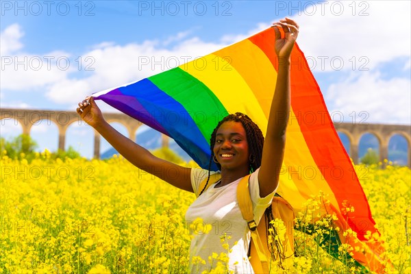 A black ethnic girl with braids holding the LGBT flag