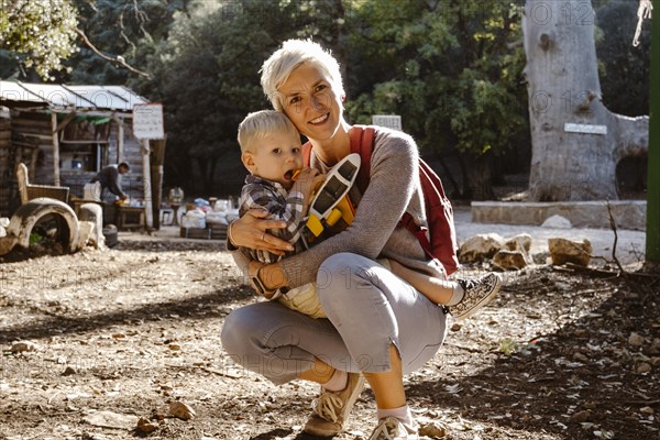 Mother hugging her two years old son wuth an airplane in Cedre Gouraud Forest in Azrou