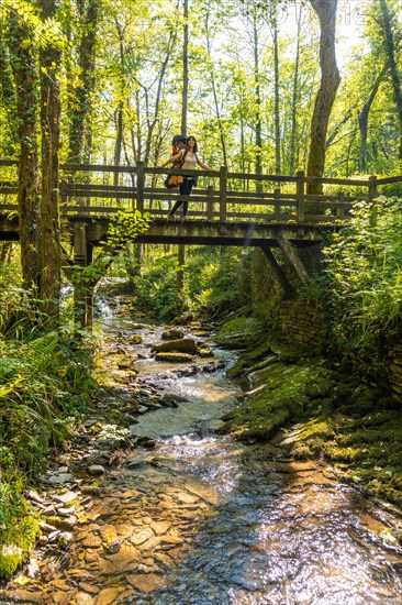 A mother with her son crossing a wooden bridge in the Pagoeta park in Aia