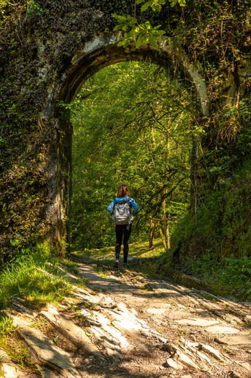 A young woman in the tunnel in the aqueduct of the Agorregi mill in the Pagoeta park in Aia