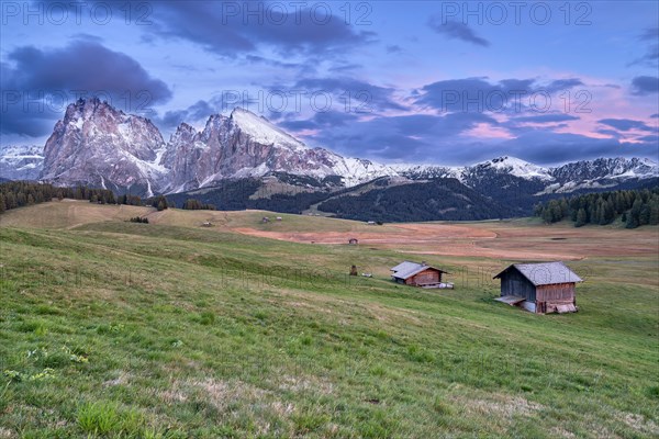 Alpine huts on autumnal alpine pastures in front of mountains