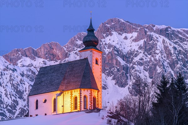 Parish church in winter landscape with Hochkoenig