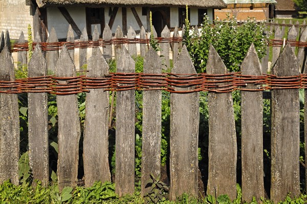 Old wooden fence connected with willow rods