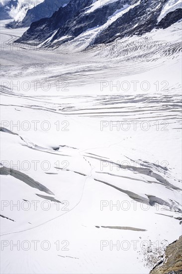 Alpine glacier hikers hike through the snow and ice