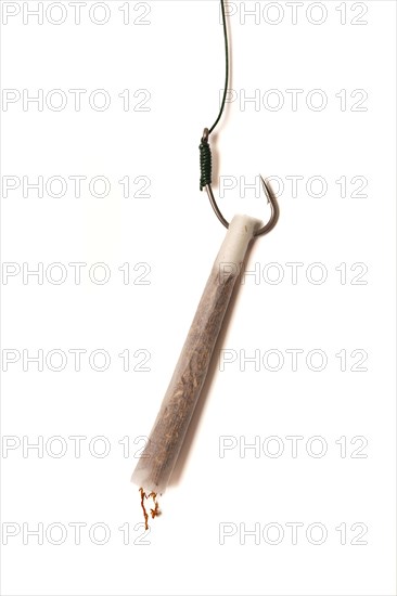 Marijuana cigarette hanging from a hook drug addiction concept close-up isolated on white background