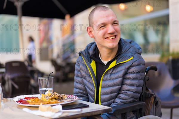 Portrait of a disabled person in a wheelchair in a restaurant smiling