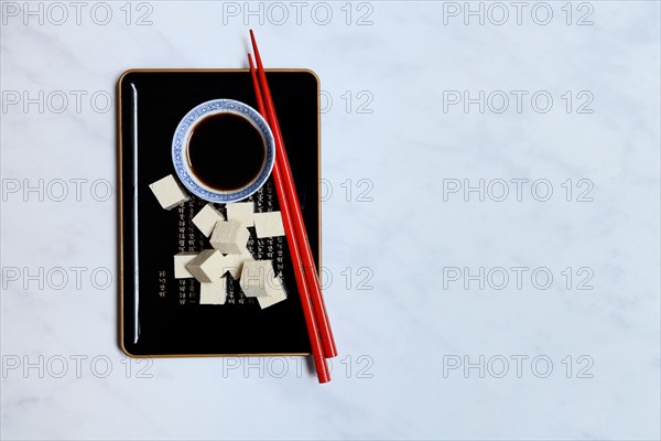 Tofu cubes and soy sauce on tray