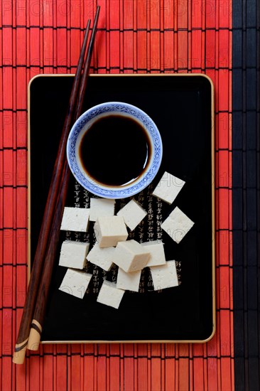 Tofu cubes and soy sauce on tray