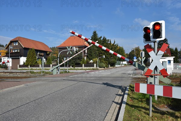 Railway barrier and St Andrews cross at a level crossing of the Harzer Schmalspurbahn