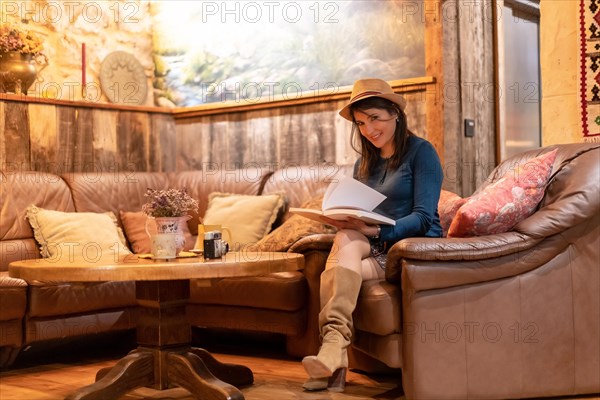 A pretty tourist with a hat and with a photo camera drinking tea in a cafe