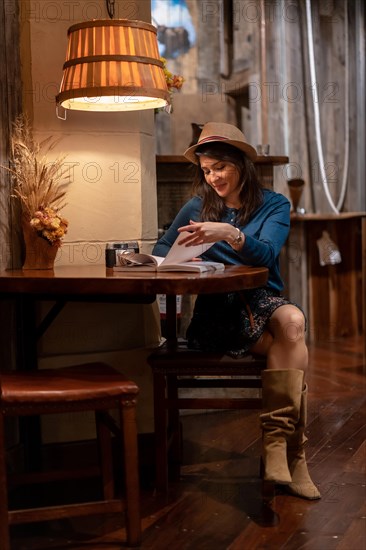 A pretty tourist with a hat and with a photo camera drinking tea in a cafe