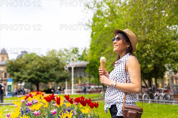 A tourist woman walking visiting the city eating an ice cream cone