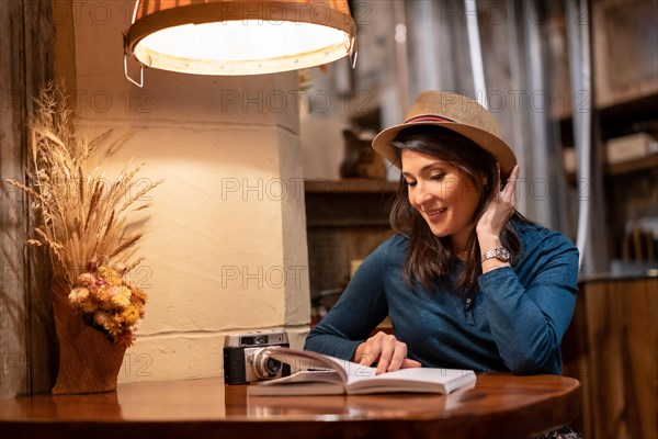 A pretty tourist with a hat and with a photo camera drinking tea in a cafe