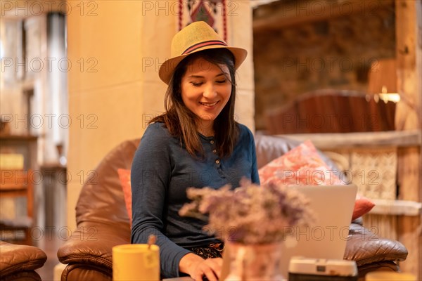 A pretty tourist in a hat and with a photo camera drinking tea in a cafeteria