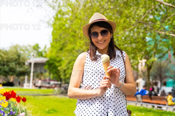 A tourist woman visiting the city eating an ice cream cone