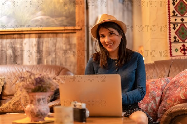 A pretty tourist in a hat and with a photo camera drinking tea in a cafeteria