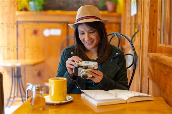 A tourist girl with a photo camera having a tea in a cafeteria terrace