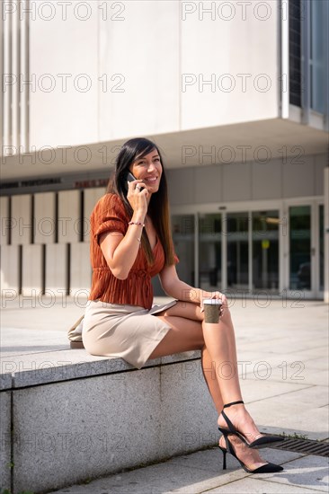 Businesswoman outside the office making a call with the phone