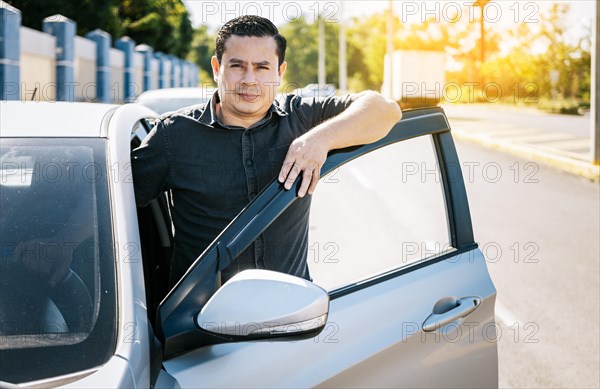 Close up of driver leaning on the car door in the street