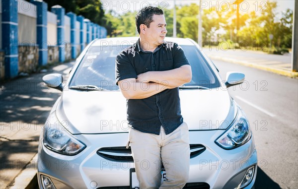 Portrait of smiling man leaning on the car