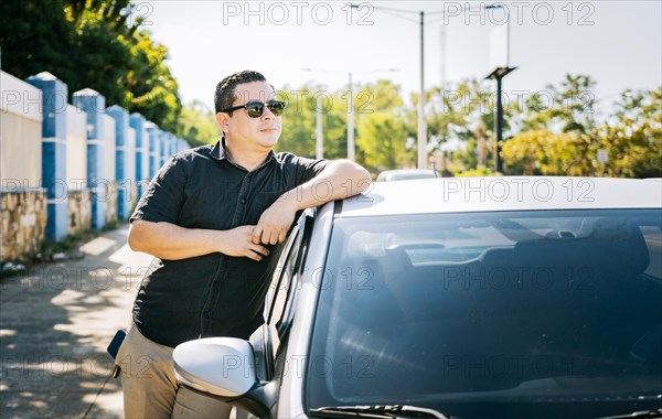 Smiling driver leaning on the car door