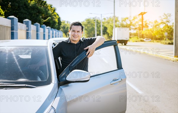 Smiling driver leaning on the car door
