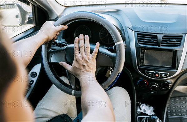 Close-up of driver honking car horn