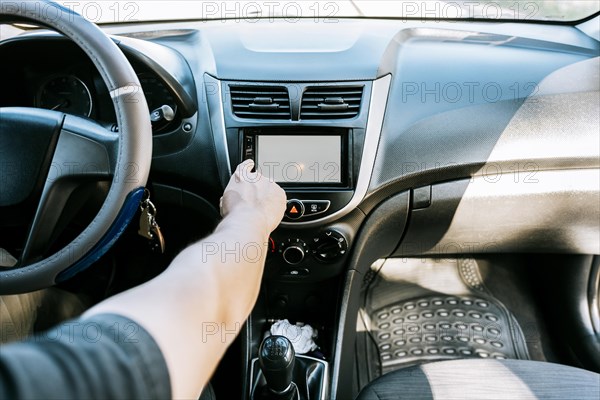 Close up of driver tuning into the radio station