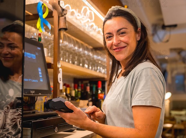 Brunette caucasian waitress cashing with card in coffee shop