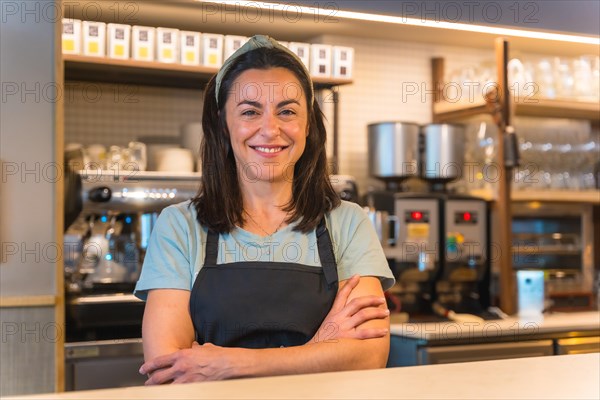 Portrait of a smiling waitress with the coffee machine in the background