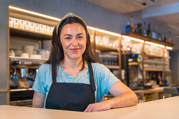 Portrait of a pretty smiling waitress with the coffee machine in the background