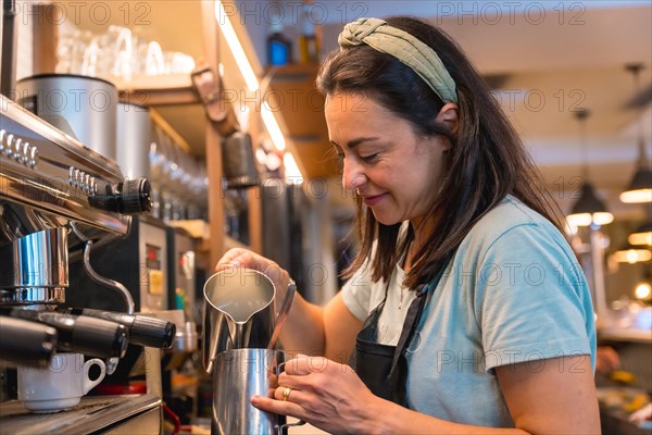 Smiling waitress in the cafeteria preparing the coffee in the coffee machine